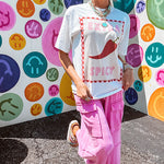 Washed white tee with pink and red checkered graphic paired with a fiery pepper design.