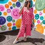 Soft, stretchy ribbed textured set in pink and red checkers with an oversized short sleeved round neck top and matching elastic waist, wide leg bottoms.