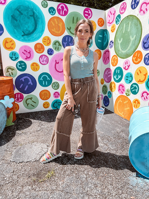 Cotton terry wide leg pants in medium brown with wide legs, exposed seams throughout, elastic drawstring waist and oversized pockets.