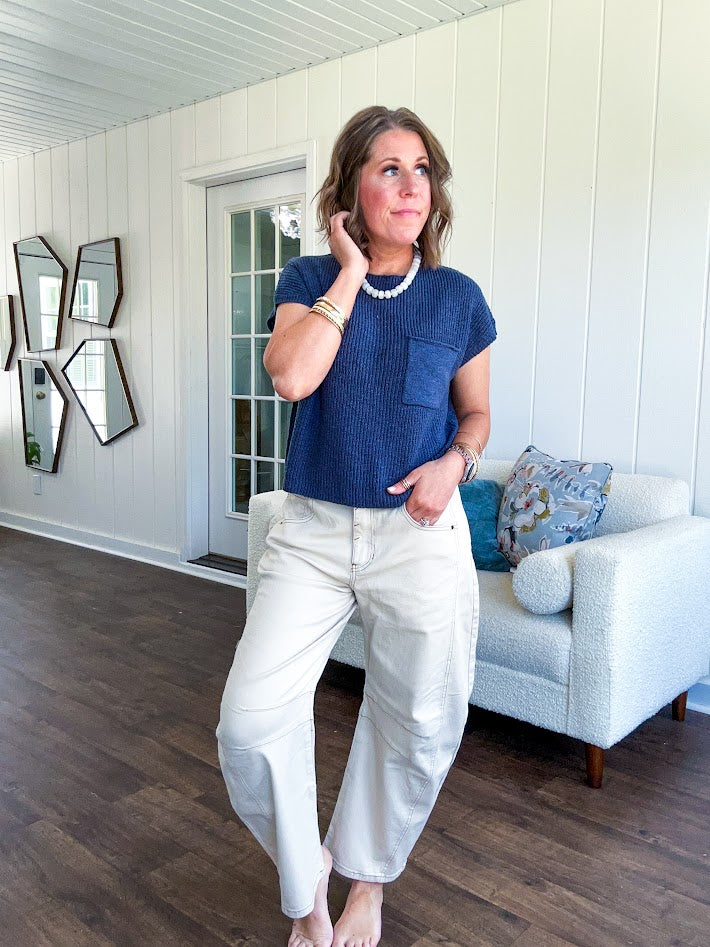 Lightweight dolman style cropped knit sweater with short sleeves, front pocket and available in three colors.