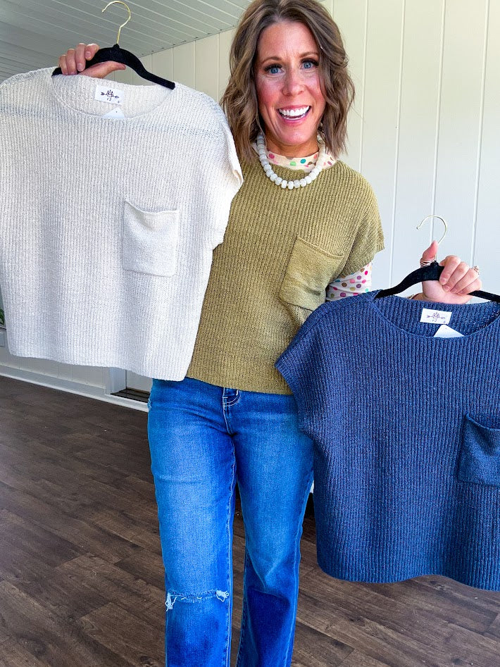 Lightweight dolman style cropped knit sweater with short sleeves, front pocket and available in three colors.