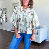 Flowy sage and ream floral blouse with billow sleeve, V neck with a tie and flowy hem.