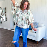 Flowy sage and ream floral blouse with billow sleeve, V neck with a tie and flowy hem.