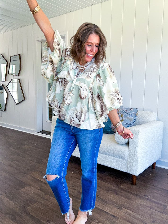 Flowy sage and ream floral blouse with billow sleeve, V neck with a tie and flowy hem.