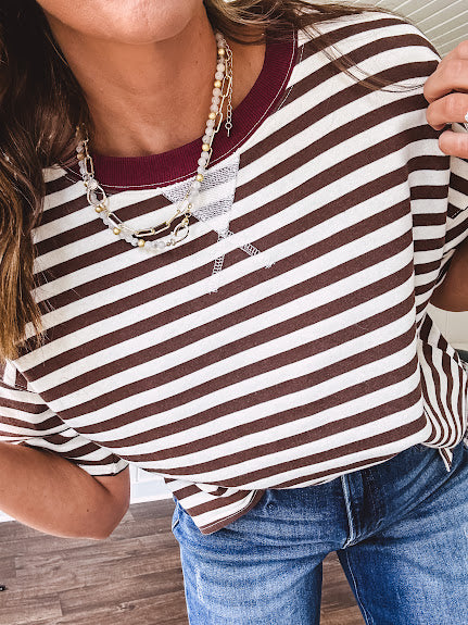 Terry-like short sleeved top with dark brown and cream stripes, split hem and maroon trim at the round neck.