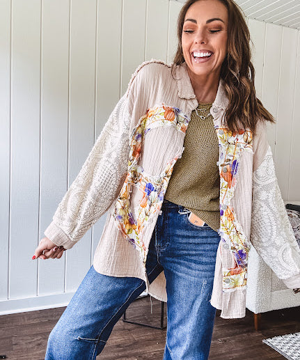 Beige cotton shacket with floral peace patch across the front, lace sleeves and metal buttons down the front. Oversized.