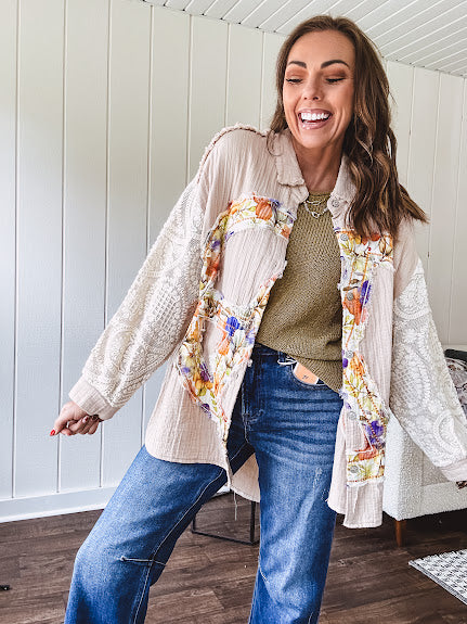 Beige cotton shacket with floral peace patch across the front, lace sleeves and metal buttons down the front. Oversized.