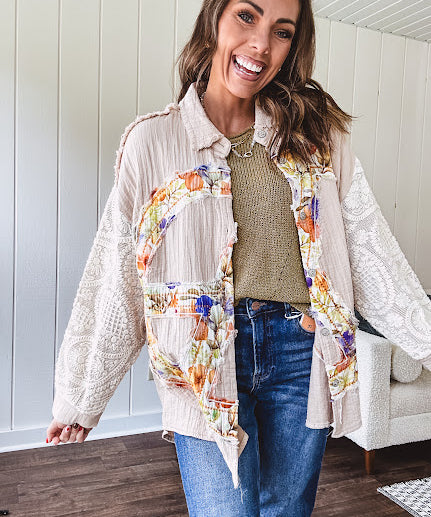 Beige cotton shacket with floral peace patch across the front, lace sleeves and metal buttons down the front. Oversized.