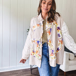 Beige cotton shacket with floral peace patch across the front, lace sleeves and metal buttons down the front. Oversized.