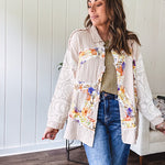 Beige cotton shacket with floral peace patch across the front, lace sleeves and metal buttons down the front. Oversized.