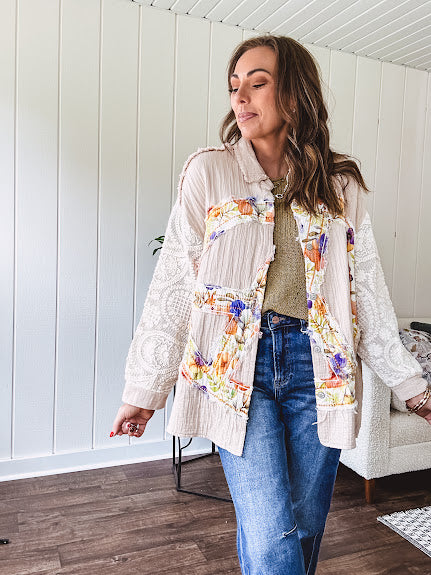 Beige cotton shacket with floral peace patch across the front, lace sleeves and metal buttons down the front. Oversized.