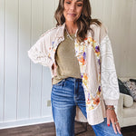 Beige cotton shacket with floral peace patch across the front, lace sleeves and metal buttons down the front. Oversized.