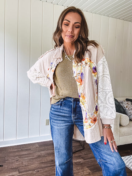 Beige cotton shacket with floral peace patch across the front, lace sleeves and metal buttons down the front. Oversized.