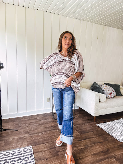 Soft open weave drop shoulder pullover with taupe, dark grey and white striping throughout, V neck design front and back and oversized fit.