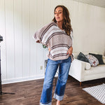 Soft open weave drop shoulder pullover with taupe, dark grey and white striping throughout, V neck design front and back and oversized fit.