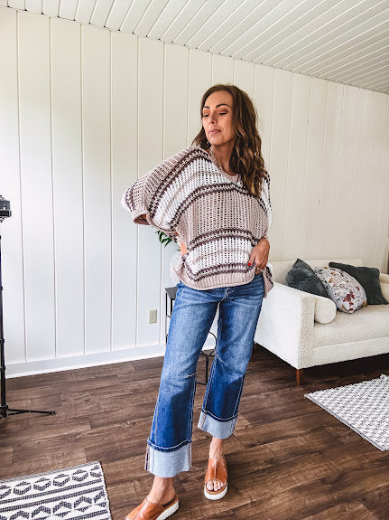Soft open weave drop shoulder pullover with taupe, dark grey and white striping throughout, V neck design front and back and oversized fit.