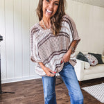 Soft open weave drop shoulder pullover with taupe, dark grey and white striping throughout, V neck design front and back and oversized fit.