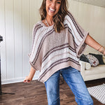 Soft open weave drop shoulder pullover with taupe, dark grey and white striping throughout, V neck design front and back and oversized fit.