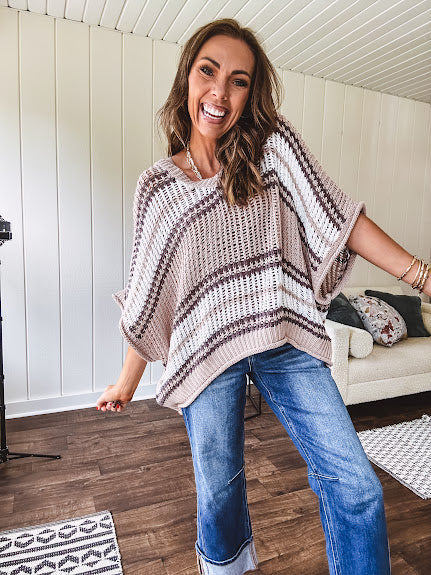 Soft open weave drop shoulder pullover with taupe, dark grey and white striping throughout, V neck design front and back and oversized fit.