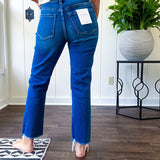 High rise dark wash denim with button and zipper closure, stretch, distressing at the knee and raw hem with straight leg.