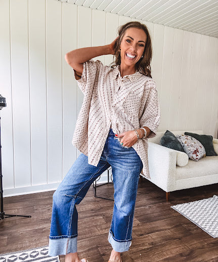 Oversized cotton blend khaki dolman style button front top with raw seams, cuffed short sleeves and dainty floral patterns in spice with mixed textures.
