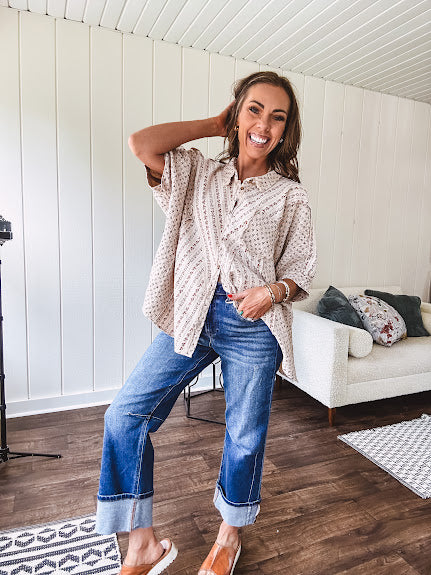 Oversized cotton blend khaki dolman style button front top with raw seams, cuffed short sleeves and dainty floral patterns in spice with mixed textures.