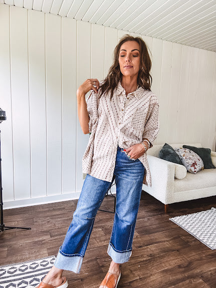 Oversized cotton blend khaki dolman style button front top with raw seams, cuffed short sleeves and dainty floral patterns in spice with mixed textures.
