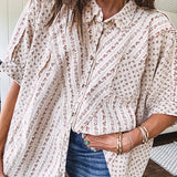 Oversized cotton blend khaki dolman style button front top with raw seams, cuffed short sleeves and dainty floral patterns in spice with mixed textures.