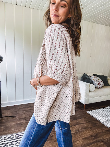 Oversized cotton blend khaki dolman style button front top with raw seams, cuffed short sleeves and dainty floral patterns in spice with mixed textures.
