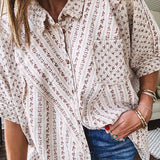 Oversized cotton blend khaki dolman style button front top with raw seams, cuffed short sleeves and dainty floral patterns in spice with mixed textures.