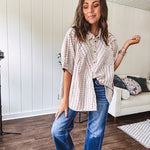Oversized cotton blend khaki dolman style button front top with raw seams, cuffed short sleeves and dainty floral patterns in spice with mixed textures.