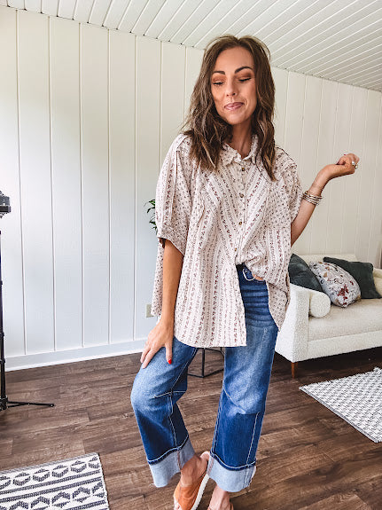Oversized cotton blend khaki dolman style button front top with raw seams, cuffed short sleeves and dainty floral patterns in spice with mixed textures.