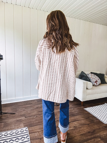 Oversized cotton blend khaki dolman style button front top with raw seams, cuffed short sleeves and dainty floral patterns in spice with mixed textures.