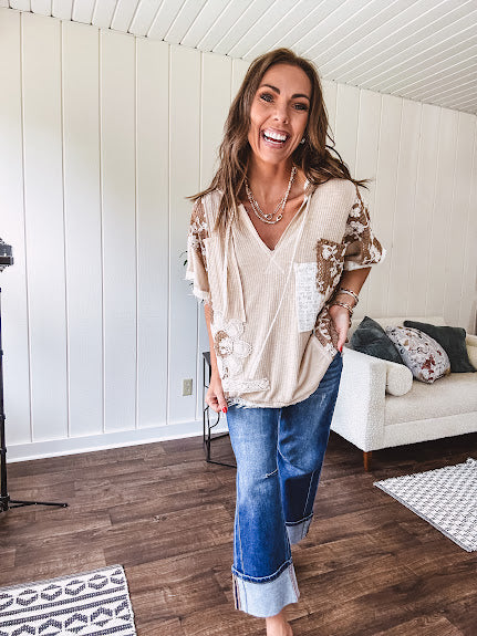 Oversized, lightweight stretchy beige ribbed top with a mix of wheat and dark tan crochet inserts and trim throughout with ivory crochet florals, hoodie and lace drawstring with lace at the wide hem and short sleeved cuffs.