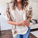 Oversized, lightweight stretchy beige ribbed top with a mix of wheat and dark tan crochet inserts and trim throughout with ivory crochet florals, hoodie and lace drawstring with lace at the wide hem and short sleeved cuffs.