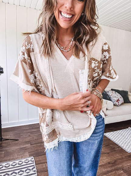 Oversized, lightweight stretchy beige ribbed top with a mix of wheat and dark tan crochet inserts and trim throughout with ivory crochet florals, hoodie and lace drawstring with lace at the wide hem and short sleeved cuffs.
