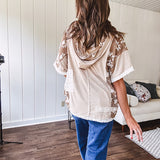 Oversized, lightweight stretchy beige ribbed top with a mix of wheat and dark tan crochet inserts and trim throughout with ivory crochet florals, hoodie and lace drawstring with lace at the wide hem and short sleeved cuffs.