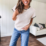Light khaki crochet knit sweater with short sleeves and contrasting black trim at the round neck and cuffs with a wide ribbed hem.