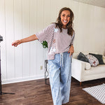 Oversized terry knit short sleeved top with cream, espresso and light blue striping and star patches throughout with exposed seams down the sides of the front and a split front hem.