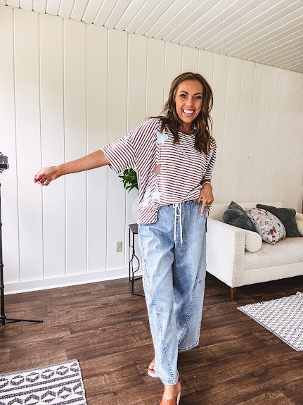 Oversized terry knit short sleeved top with cream, espresso and light blue striping and star patches throughout with exposed seams down the sides of the front and a split front hem.