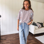 Oversized terry knit short sleeved top with cream, espresso and light blue striping and star patches throughout with exposed seams down the sides of the front and a split front hem.