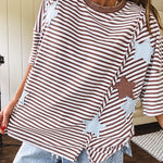 Oversized terry knit short sleeved top with cream, espresso and light blue striping and star patches throughout with exposed seams down the sides of the front and a split front hem.