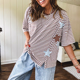 Oversized terry knit short sleeved top with cream, espresso and light blue striping and star patches throughout with exposed seams down the sides of the front and a split front hem.