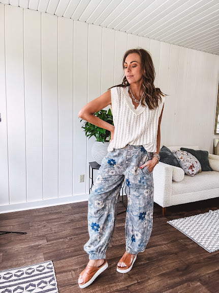 Washed navy thin, lightweight wide leg pants with taupe and navy florals throughout, metal floral button down closure, elastic back waist, elastic cuffs and side and oversized back pockets.