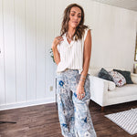 Washed navy thin, lightweight wide leg pants with taupe and navy florals throughout, metal floral button down closure, elastic back waist, elastic cuffs and side and oversized back pockets.
