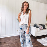 Washed navy thin, lightweight wide leg pants with taupe and navy florals throughout, metal floral button down closure, elastic back waist, elastic cuffs and side and oversized back pockets.