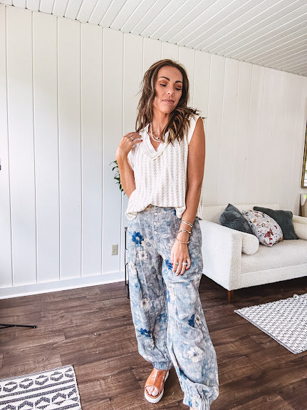 Washed navy thin, lightweight wide leg pants with taupe and navy florals throughout, metal floral button down closure, elastic back waist, elastic cuffs and side and oversized back pockets.