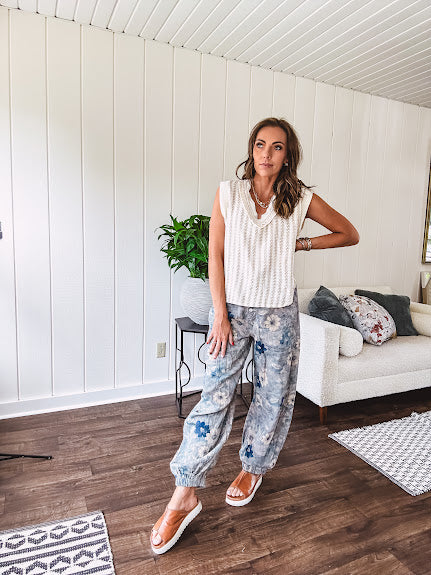 Washed navy thin, lightweight wide leg pants with taupe and navy florals throughout, metal floral button down closure, elastic back waist, elastic cuffs and side and oversized back pockets.