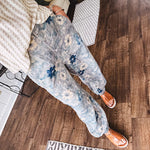 Washed navy thin, lightweight wide leg pants with taupe and navy florals throughout, metal floral button down closure, elastic back waist, elastic cuffs and side and oversized back pockets.