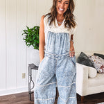 Vintage light wash denim and twill overalls with silver metal adjustable strap hardware, side zip, side and back pockets with ivory eyelet trim and cutouts throughout, wide leg design.